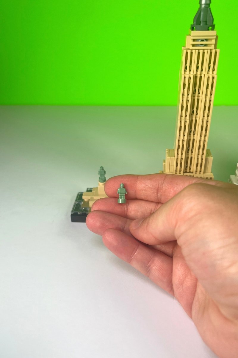 A hand holding mini LEGO lady liberty peices